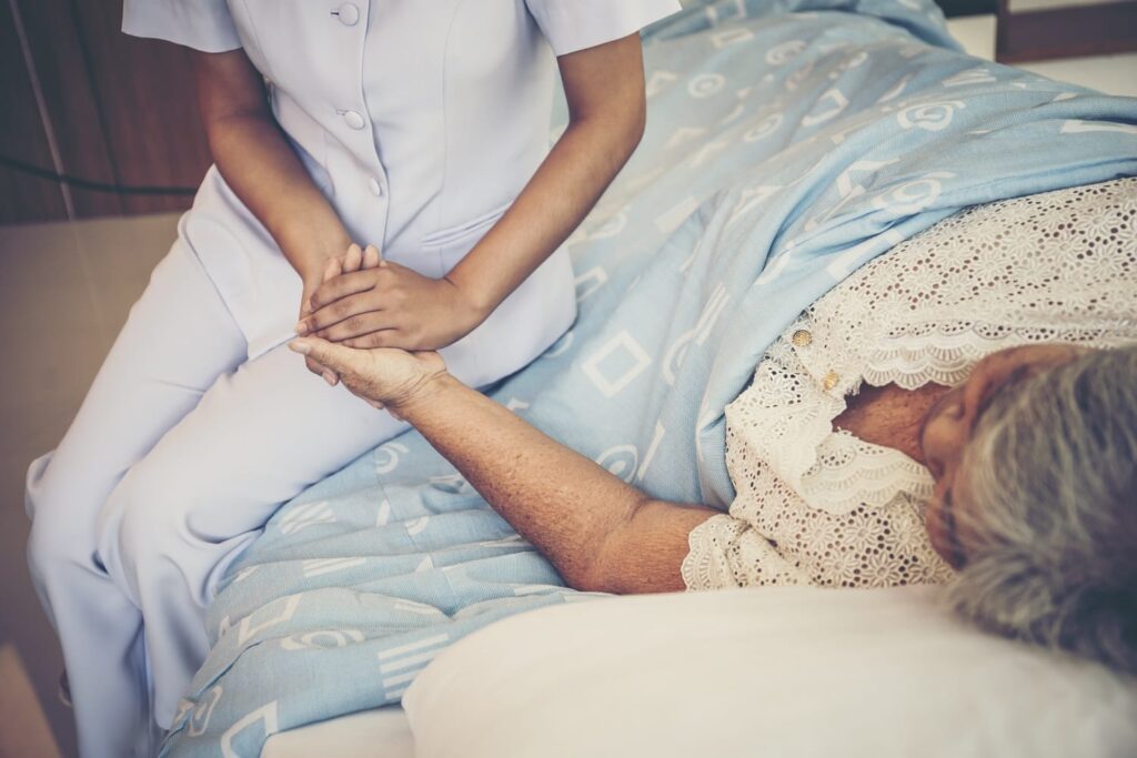 Close up of Young Nurse take care for elderly patients holding h
