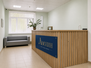 Стойка ресепшн пансионата «Авелин» с синей вывеской и диваном в зоне ожидания